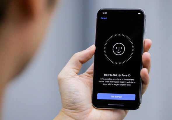 FILE PHOTO:  An attendee uses the Face ID function on the new iPhone X during a presentation for the media in Beijing